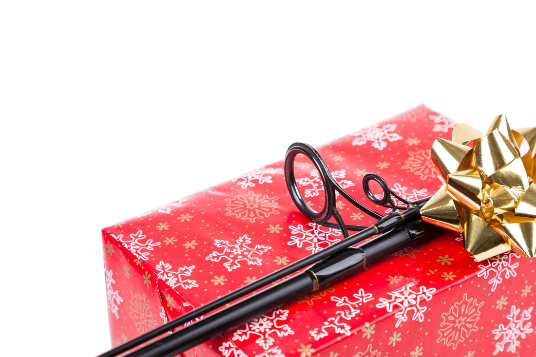 Fishing rod resting on top of a wrapped present.